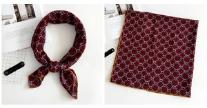 Detail of burgundy linen-blend silk scarf featuring blue heart patterns and yellow edges