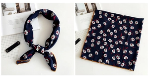 Detail of navy blue floral linen scarf with contrast yellow edges and silky texture