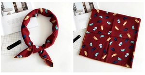 Detail of burgundy linen silk square scarf with blue and gold feather patterns