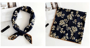 Detailed view of navy blue floral linen scarf with orange stitched hem and flower pattern
