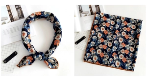 Detail of navy linen square scarf with floral print and orange rolled edge stitching