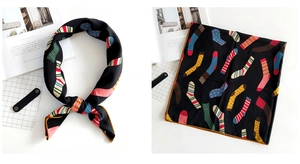 Detail view showing colorful sock pattern prints on a smooth black square silk scarf