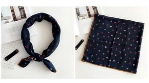 Detail showing vintage floral navy silk scarf with orange rolled edges and accessories