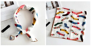 Close-up of linen-feel square scarf featuring colorful sock print and brown rolled edges