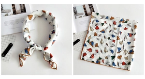 Detail of linen texture silk scarf with colorful maple leaf patterns and brown hem stitching