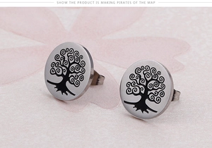 Macro shot of silver stainless steel round stud earrings with black Tree of Life engraving