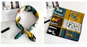 Detail of equestrian print silk scarf with colorful horse patterns and navy borders