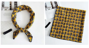 Detail of yellow paisley silk scarf with rolled edges and elegant pattern design