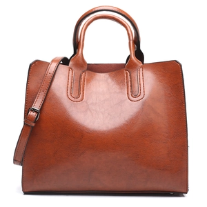 Chic brown leather tote bag with dual handles and detachable shoulder strap on white backdrop