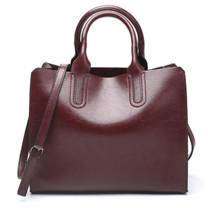 Elegant deep red leather tote bag with dual handles and adjustable strap for women