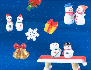 Collection of resin Christmas miniatures featuring snowmen, golden bells, and gift boxes
