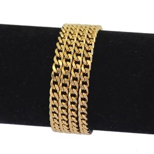 Detail of 3mm gold Cuban chain wrapped on a black velvet display stand with high gloss