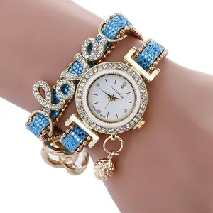Macro view of blue glitter wrap bracelet watch with rhinestone LOVE charm and pendant
