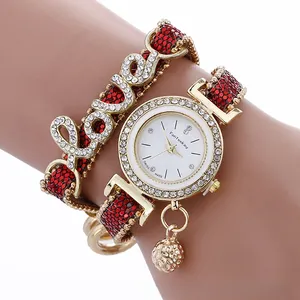 Macro view of gold rhinestone watch with red leather strap and matching LOVE bracelet