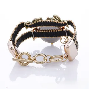 Detail view of gold alloy watch with LOVE bracelet design and black woven strap