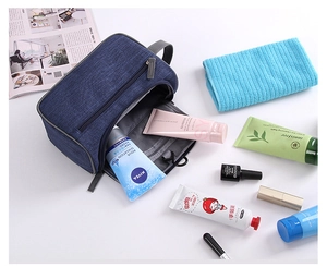 Flat lay of a blue waterproof toiletry bag with zipper compartments and side handle