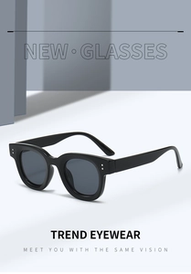 Nahaufnahme der schwarzen ovalen Sonnenbrille mit silbernen Nieten und dunklen Gläsern