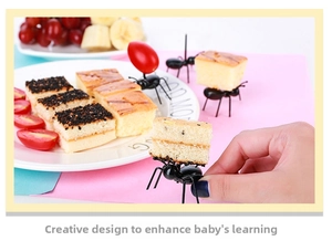 Close-up of creative black ant shaped fruit forks used on appetizers and cakes