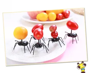 Creative black ant-shaped fruit forks used on fresh tomatoes and grapes for parties