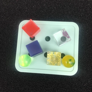 Primer plano de varios colgantes de resina en forma de esfera y cubo con flores secas