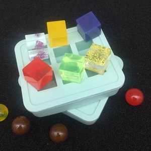 Primer plano del molde de silicona para cubos de resina con flores secas y colores vivos