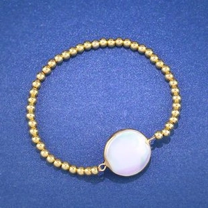 Detailed top view of gold beaded bracelet with a large purple luster mother of pearl stone