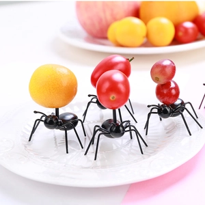 Creative black ant-shaped fruit picks set for party snacks decoration on a white plate