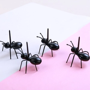 Set of 4 creative black ant-shaped plastic fruit picks on a dual-tone background
