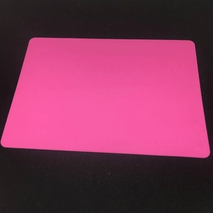 Close-up of pink waterproof silicone placemat with rounded corners on black background