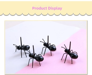 Detail showing four realistic black ant fruit picks on a clean pink background