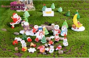 Detailed close-up of miniature Christmas figurines including Santa and snowmen on green grass