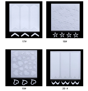 Detail view of white French manicure nail stickers with V-shape, star, heart and wave patterns