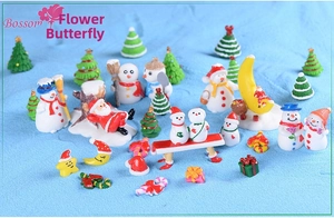 Detailed collection of miniature resin Santa Claus and snowman figurines on blue sand