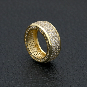 Close-up of gold-plated hip hop ring featuring multi-row pave cubic zirconia stones