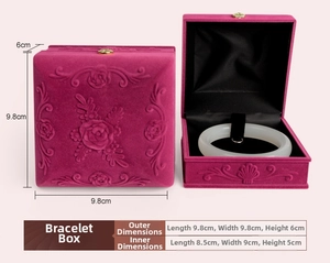 Detail view of a rose red velvet jewelry box with embossed floral patterns for bracelets