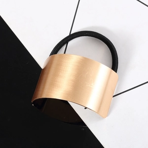 Élastique à cheveux minimaliste en métal brossé doré avec bandeau sur fond géométrique