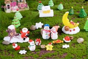 Macro view of a Christmas micro landscape featuring a resin snowman and Santa on moss