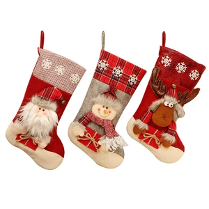 Trois chaussettes de Noël festives avec décorations de Père Noël, bonhomme de neige et renne