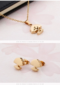 Macro shot of 18K gold plated tree pendant and earrings set on floral gift card