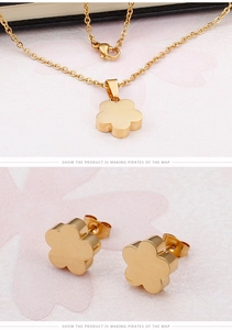 Detailed close-up of golden flower pendant necklace and stud earrings jewelry set