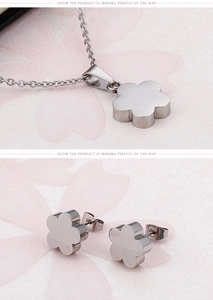 Close-up of polished silver floral necklace pendant and matching stud earrings set