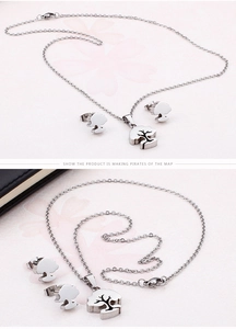 Detail view of silver Tree of Life necklace and earrings set on light pink background