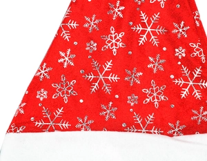 Detail of red plush Christmas hat with silver snowflake patterns and white faux fur trim