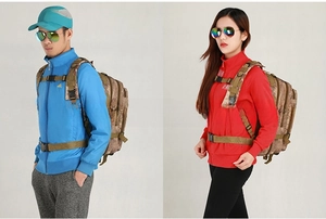 Front view of tactical camouflage backpacks worn by male and female hikers in studio