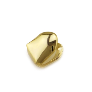 Macro shot of single 18K gold plated vampire fang grillz with polished mirror finish