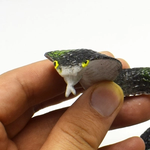 Close-up of realistic cobra toy head featuring black scale textures and yellow spots