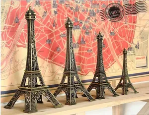 Set of four bronze Eiffel Tower models in different sizes with vintage Paris map background