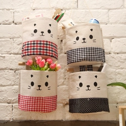 Detailed view of four wall-hanging storage bags with cute cat motifs and plaid patterns