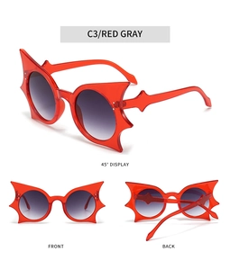 Détail des lunettes de soleil chauve-souris avec monture rouge et croix argentée