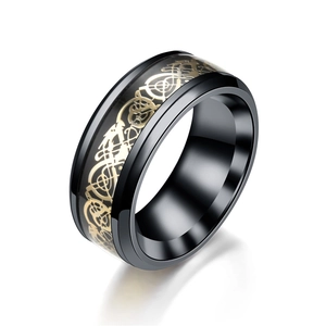 Detalle macro del anillo tótem de dragón negro y oro con textura de acero inoxidable